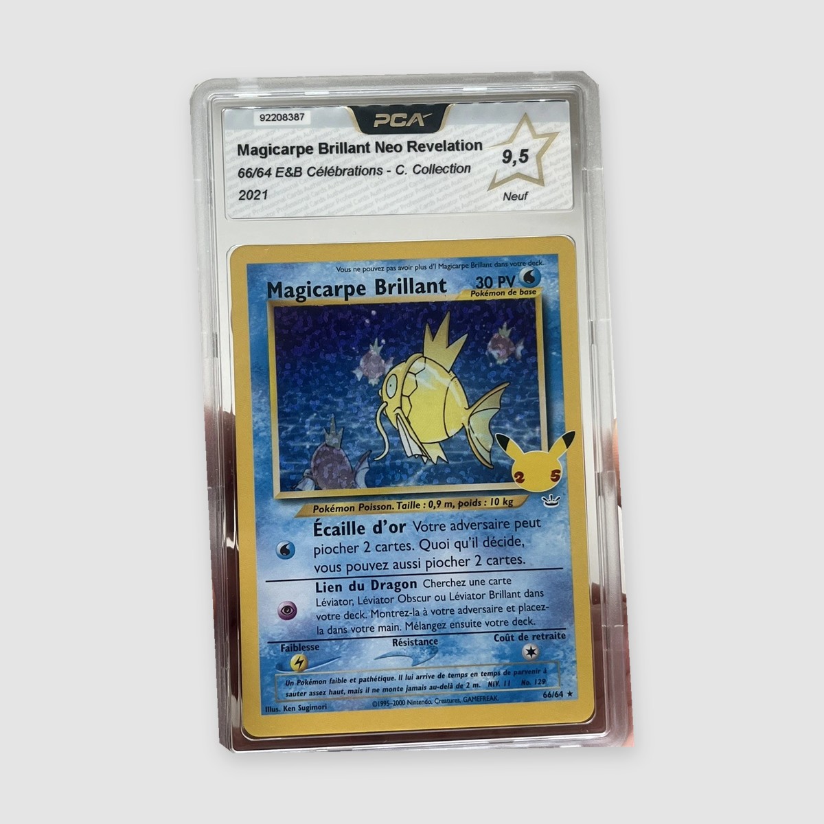 Magicarpe Brillant 66/64 Célébrations PCA 9,5 FR, vue rapprochée de la carte et du boîtier sur fond gris
