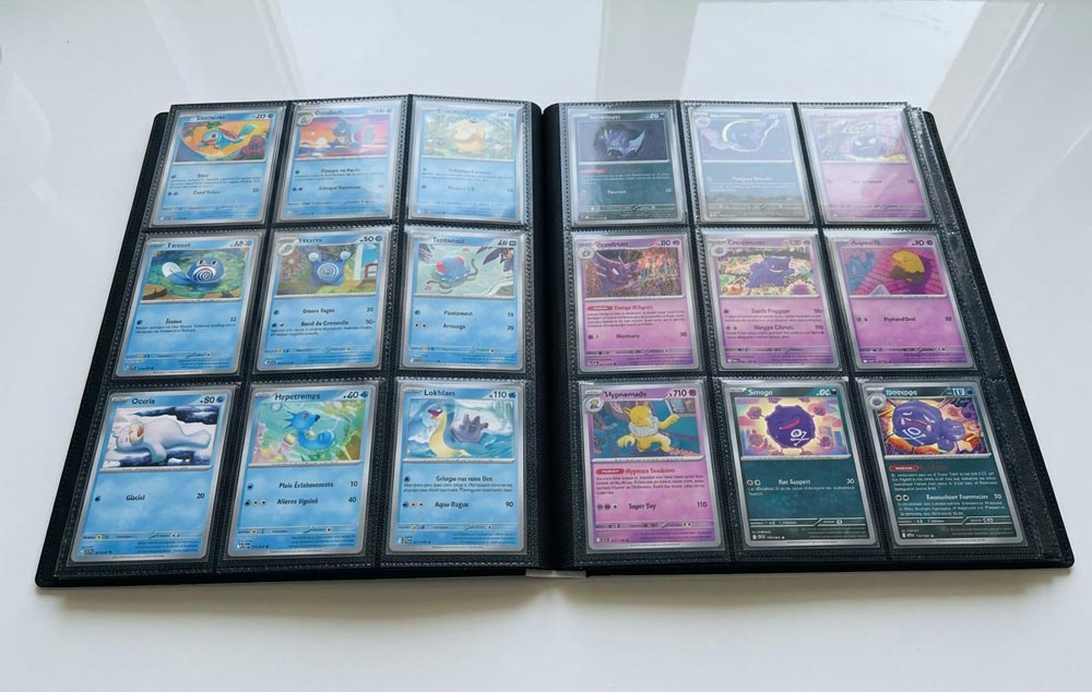 Classeur ouvert avec neuf cartes Pokémon bleues à gauche et neuf cartes aux teintes violettes et sombres à droite.
